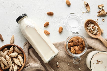 Tasty almond milk on white background
