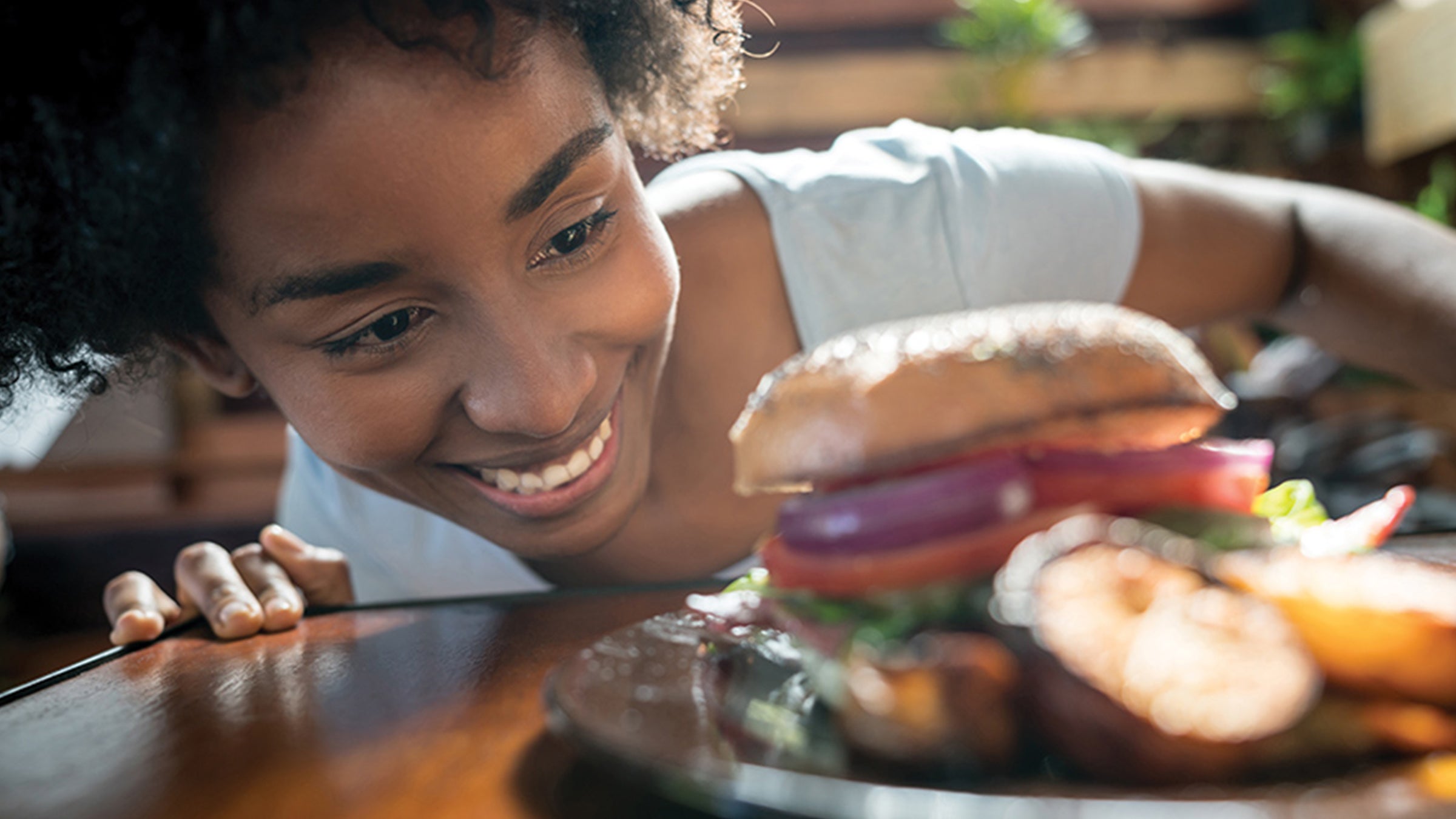 Woman looking at burger.