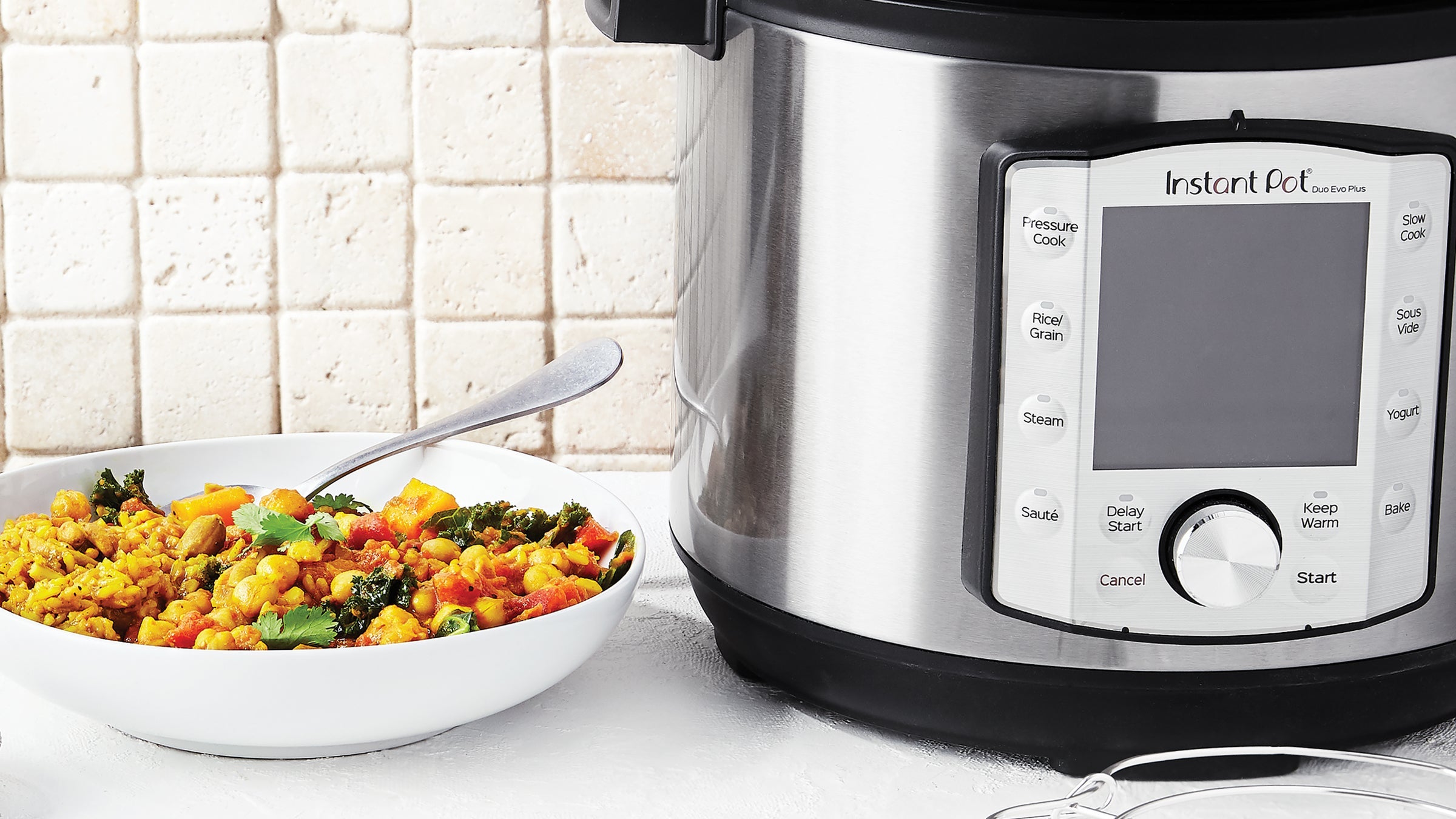 Instant Pot on a kitchen counter next to a bowl of curry