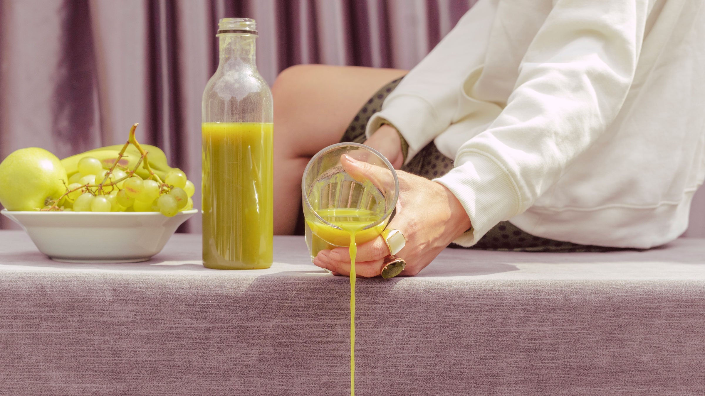 Woman spills a cup of green juice