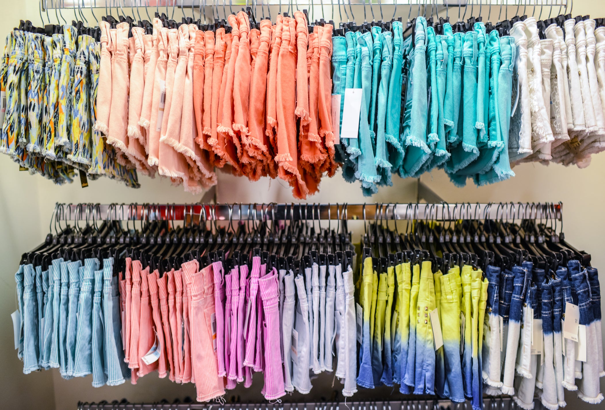what is fast fashion this image shows a rack of cut off jean shorts in a wide array of colors and patterns