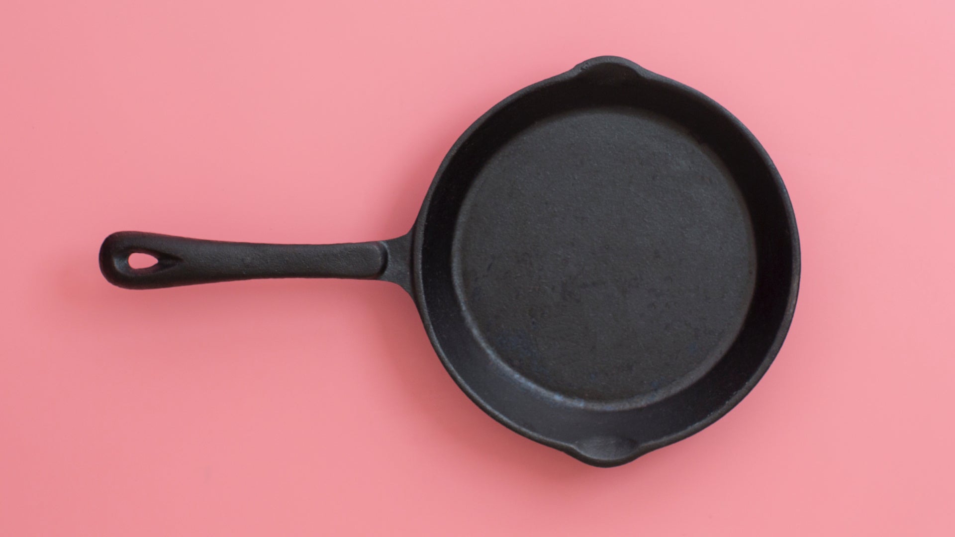 vintage cast iron skillet on pink background